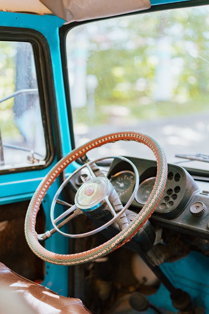 Close-up of a vintage car's steering wheel and dashboard with a retro look.